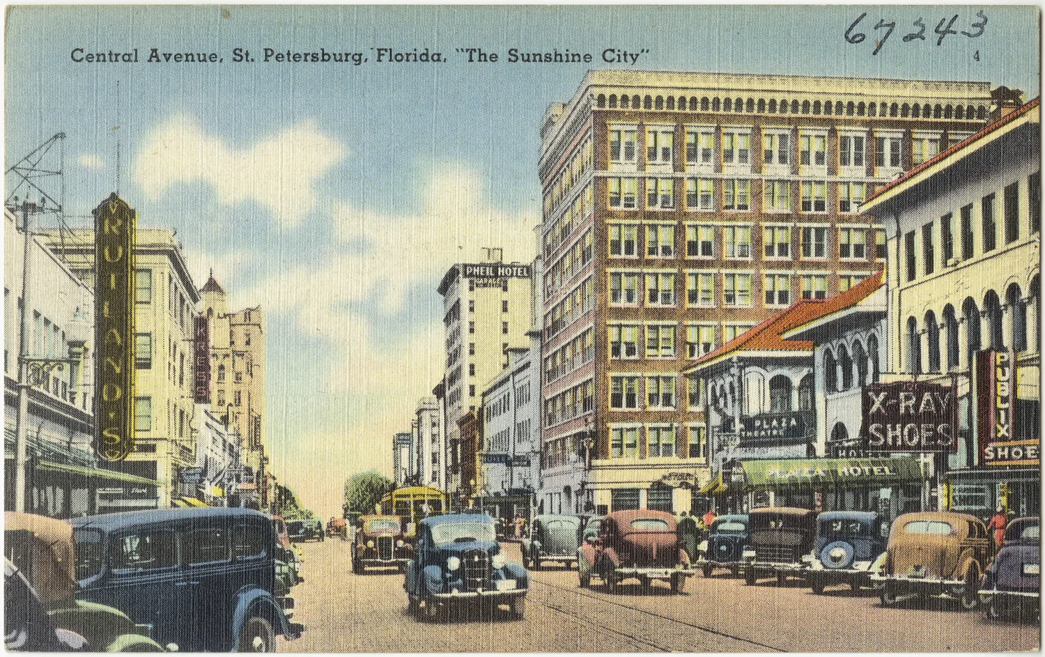 Vintage linen postcard of Central Avenue, St. Petersburg, lined with 1940s cars and storefronts under a blue sky.